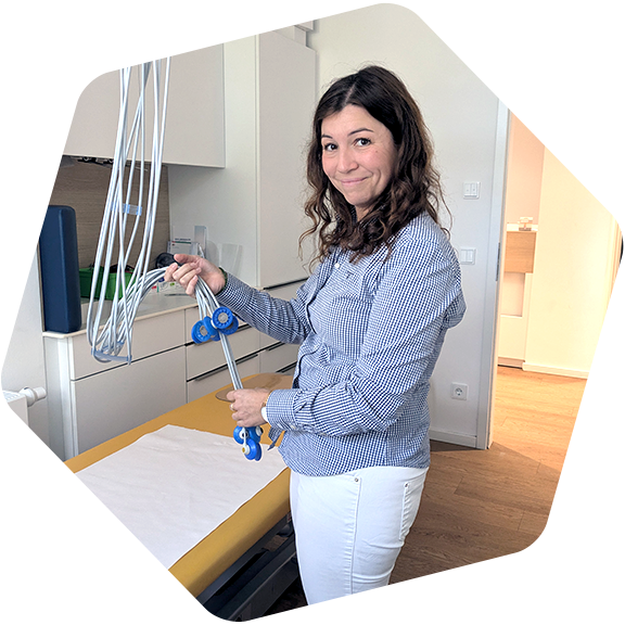 Yolanda Morais hält die Kabel mit den Elektroden für das EKG in die Kamera